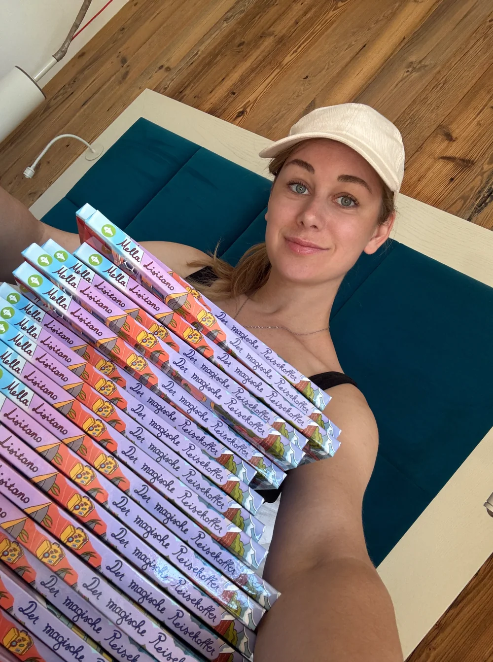 Mella mit einem Stapel ihrer Kinderbücher